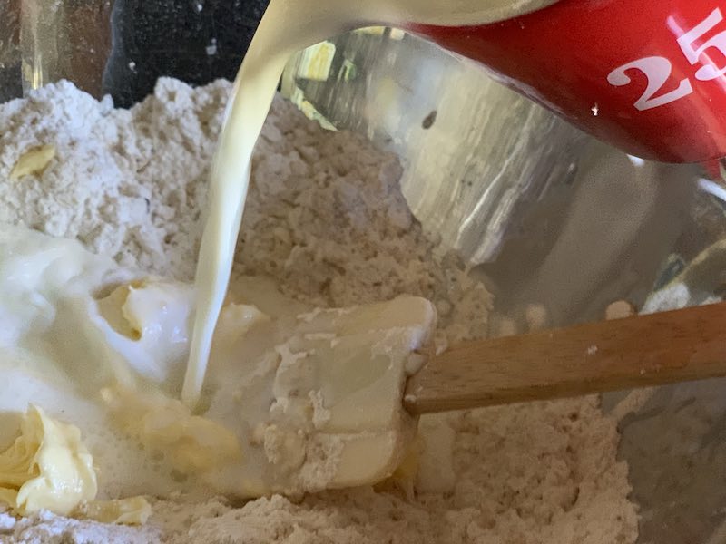 Adding the milk to the mixture for clone scones